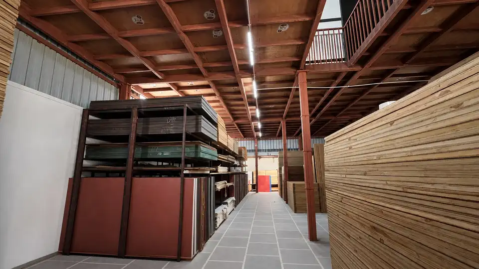 Warehouse aisle lined with plywood and board stacks on industrial racks